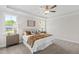 Comfortable bedroom with a tray ceiling, ceiling fan, and ample natural light at 123 Wichita Way, Louisburg, NC 27549