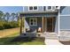 Inviting front porch with comfortable seating and stone accents on the exterior with dark wood door at 123 Wichita Way, Louisburg, NC 27549