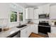 Featuring stainless appliances, white cabinetry, and granite countertops. The window overlooks the porch at 123 Wichita Way, Louisburg, NC 27549