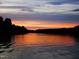 Sunset view of a lake with trees silhouetted against a colorful sky at 123 Wichita Way, Louisburg, NC 27549