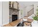 Living area boasting a stone fireplace, access to the outdoors, and adjacent staircase at 123 Wichita Way, Louisburg, NC 27549