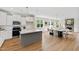 Bright open-concept kitchen with white cabinets, open to dining space with a fireplace. Hardwood floors at 123 Wichita Way, Louisburg, NC 27549