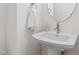 Pedestal sink with brushed nickel faucet, round mirror, and white towel at 123 Wichita Way, Louisburg, NC 27549
