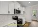 White kitchen with stainless steel appliances and mosaic backsplash at 137 Buckaroo Dr, Louisburg, NC 27549