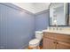 Powder room with stylish blue paneling, a modern vanity, and unique mirror for guests at 1409 Sedgefield St, Durham, NC 27705