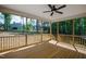 Covered porch with natural wood floors, and a fan for optimal comfort at 235 Sequoia Dr, Louisburg, NC 27549