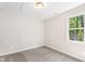 Bright bedroom with neutral carpet, a window with nature views, and soft lighting at 235 Sequoia Dr, Louisburg, NC 27549