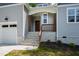 Inviting front porch with stone steps and wooden pillars, leading to a stylish front door at 235 Sequoia Dr, Louisburg, NC 27549