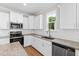 Modern kitchen with white cabinets, granite counters, stainless appliances, and herringbone backsplash at 235 Sequoia Dr, Louisburg, NC 27549