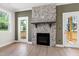 Cozy living room showcasing a stone fireplace, access to outdoor deck, and natural light at 235 Sequoia Dr, Louisburg, NC 27549