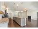 Open kitchen view to living room featuring granite counters, stainless appliances, and dark hardwood flooring at 7533 Poplar Meadow Ln, Raleigh, NC 27616