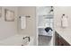 Bright bathroom featuring a soaking tub and a doorway view of the bedroom with a ceiling fan at 8204 Yaxley Hall Dr, Raleigh, NC 27616