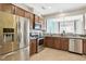 Bright kitchen featuring stainless steel appliances, wooden cabinets, and view into dining area at 8204 Yaxley Hall Dr, Raleigh, NC 27616