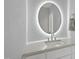 Bathroom featuring a modern, backlit, circular mirror, sleek countertop, and brushed nickel fixtures at 1309 Briar Patch Ln, Raleigh, NC 27615