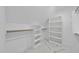 Walk-in closet featuring built-in shelving and custom-built wood rods on top of marbled tile flooring at 1309 Briar Patch Ln, Raleigh, NC 27615