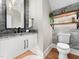 Modern bathroom with granite countertop, white cabinets and a stone feature wall at 145 Wiggins Rd, Louisburg, NC 27549