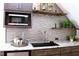 Modern wet bar with granite countertops and wave patterned tile at 145 Wiggins Rd, Louisburg, NC 27549