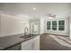 An open living room with hardwood floors, large windows, and a ceiling fan at 1817 Hinesley Dr, Durham, NC 27703
