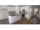 This kitchen features stainless steel appliances, white cabinets, a center island with sink, and hardwood floors at 1825 Hinesley Dr, Durham, NC 27703