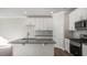 Bright kitchen with a center island, stainless steel appliances, white cabinets, and hardwood floors at 1825 Hinesley Dr, Durham, NC 27703