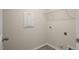 Functional laundry room features tile flooring, laundry hookups and a wire shelf for ample storage at 1825 Hinesley Dr, Durham, NC 27703