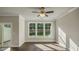 Well-lit living room features hardwood floors, large windows overlooking the backyard, and a ceiling fan at 1825 Hinesley Dr, Durham, NC 27703
