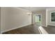 Bright living room featuring hardwood floors, sliding glass doors to backyard, and modern lighting fixtures at 1825 Hinesley Dr, Durham, NC 27703