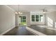 Bright living room with hardwood floors, large windows, sliding glass doors, a ceiling fan, and modern lighting at 1825 Hinesley Dr, Durham, NC 27703