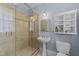 A bathroom featuring a tiled walk-in shower, pedestal sink, and classic design elements at 417 Elm St, Raleigh, NC 27604