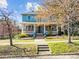 Charming two-story blue home featuring a welcoming front porch and beautiful landscaping at 417 Elm St, Raleigh, NC 27604