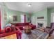A living room with a red sectional sofa, fireplace, hardwood floors, and natural light at 417 Elm St, Raleigh, NC 27604