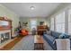 Cozy living room featuring a fireplace, piano, hardwood floors, and natural light at 417 Elm St, Raleigh, NC 27604