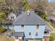 This two-story home features blue siding, a stone patio, a grill and is overlooked by a mature tree canopy at 417 Elm St, Raleigh, NC 27604