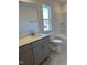 Modern bathroom showcasing a gray vanity, hexagon tile floors, and a clean, white shower-tub combination at 1113 Mountain Crown St, Durham, NC 27703