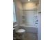 Clean bathroom design featuring a white shower-tub combo, hexagon tile flooring, and a standard toilet at 1113 Mountain Crown St, Durham, NC 27703