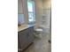 Well-lit bathroom featuring gray vanity, hexagon tile flooring, and a shower-tub combination at 1113 Mountain Crown St, Durham, NC 27703