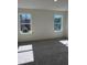 Sunlit bedroom with neutral carpet, white walls, and large windows offering natural views at 1113 Mountain Crown St, Durham, NC 27703