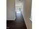 Inviting hallway with dark wood-look flooring leading to a bright, light-filled room at 1113 Mountain Crown St, Durham, NC 27703