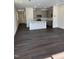 Open floor plan integrating the living area and kitchen, featuring modern gray cabinets and hardwood flooring at 1113 Mountain Crown St, Durham, NC 27703
