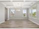 Spacious dining room with large windows, coffered ceiling and modern chandelier at 155 Shelby Meadow Ln, Angier, NC 27501
