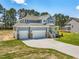 Two-story home featuring a manicured lawn, a three car garage, and a charming front porch at 155 Shelby Meadow Ln, Angier, NC 27501