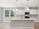 Bright kitchen with white cabinets, pendant lights over island, and views to backyard at 155 Shelby Meadow Ln, Angier, NC 27501