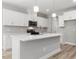 Modern kitchen with white cabinets, stainless steel appliances, and a spacious island at 155 Shelby Meadow Ln, Angier, NC 27501