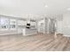 Open-concept kitchen featuring white cabinets, a large island, and sleek luxury vinyl plank flooring at 155 Shelby Meadow Ln, Angier, NC 27501