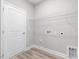 Laundry room has white door, vinyl floors, and wire shelving above hookups at 155 Shelby Meadow Ln, Angier, NC 27501