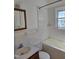 Clean bathroom features white tiled walls, a tub, and a sink with a wood-framed mirror at 2219 Fitzgerald Ave, Durham, NC 27707