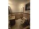 This bathroom features a toilet, vanity, sink, mirror, and tiled walls at 2219 Fitzgerald Ave, Durham, NC 27707