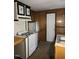This is a compact kitchen featuring a gas stove, stainless steel sink, and wood-paneled walls at 2219 Fitzgerald Ave, Durham, NC 27707
