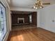 Open-concept space with hardwood flooring connects the living room and brick fireplace area at 2219 Fitzgerald Ave, Durham, NC 27707