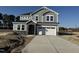 Two-story home featuring gray siding, stone accents, a two car garage and a concrete driveway at 23 Barrow Ct, Angier, NC 27501